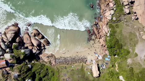 Drone-aerial-video-top-of-beach-with-rocks-and-fisherman-houses