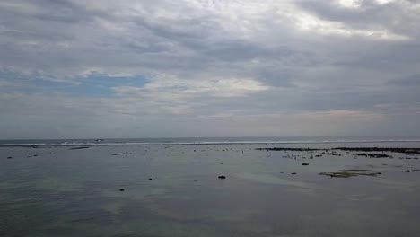 Olas-En-El-Borde-Del-Arrecife-Local-En-Reflujo,-Cielo-Nublado-Hermosa-Vista-Aérea-Vuelo-Panorama-Descripción-General-Imágenes-De-Drones-Pantai-Kuta-Lombok-Indonesia-2017