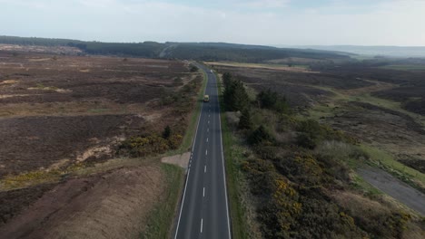 Aerial-of-alone-bus-driving-in-the-street-of-Goathland---North-York-Moors-National-Park-UK