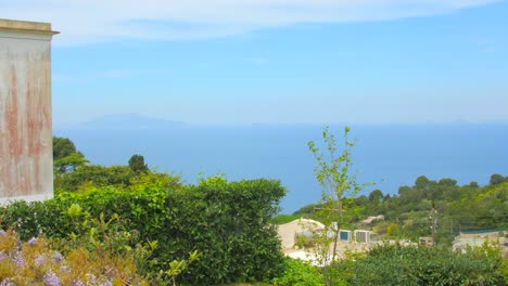 Mit-Blick-Auf-Die-Küste-Und-Das-Meer-Mit-Bunten-Häusern,-Blauem-Wasser-Und-Klarem-Himmel-Im-Hintergrund-In-Capri,-Italien