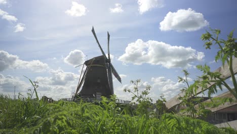 View-Of-Netherlands-Old-Windmill-In-A-Grassy-Area-Near-A-Farm---wide-shot