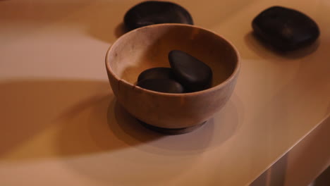Heating-up-massage-stones-on-a-wooden-cup