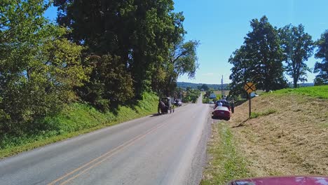 Un-Caballo-Amish-Y-Un-Buggy-Trotando-Por-Una-Carretera-Rural-Pasando-Autos,-En-Un-Hermoso-Día-Soleado