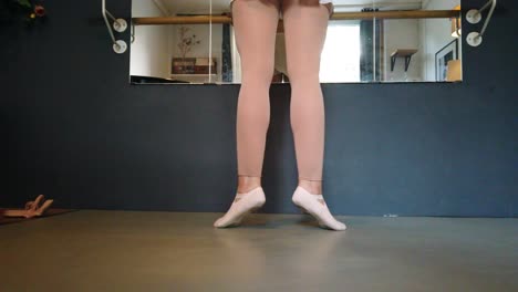On-tiptoe,-Exercise-position-Stunning-dog-cam-of-a-Ballerina-with-white-skirt-and-golden-body-at-slow-motion-foto-video-shoot-in-berlin-urban-ballet-Studio