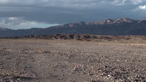 Crushed-rock-gravel-plain-with-Sierra-Nevada-background-in-Death-Valley,-California,-Aerial-dolly-right-shot