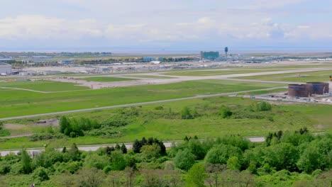 Evergreen-Airport-Field-Of-YVR--Vancouver-International-Airport-With-A-Landing-Plane-In-The-Background-In-Richmond,-British-Columbia,-Canada