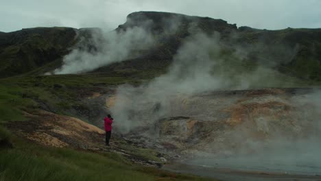 Isländische-Landschaft,-Geothermischer-Heißer-Dampfrauch,-Entfernte-Figur-Eines-Fotografen,-Der-Ein-Bild-Einer-Ganzen-Szene-Macht,-Weitwinkelaufnahme