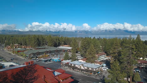 Drone-footage-of-South-Lake-Tahoe-and-snow-capped-mountains-in-the-background