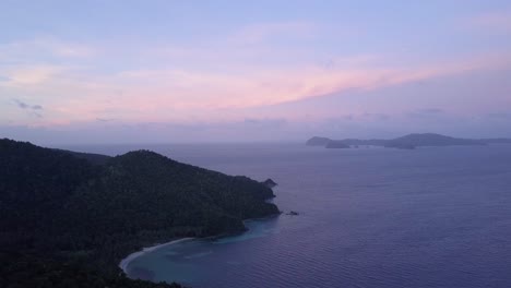 Aerial-view-of-pastel-colored-dawn-and-tropical-island-with-beach-and-clear-waters-in-the-Philippines