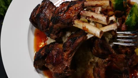 Overhead-view-of-lamb-chops-with-fork-picking-up-rice