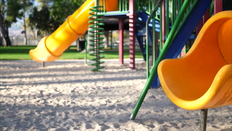 Close-up-of-a-yellow-slide-in-an-empty-kids-park-playground-with-bokeh-and-copy-space-in-the-background