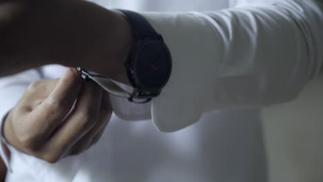 Close-up-of-man-in-dress-shirt-putting-on-watch