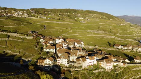 Orbiting-then-overflying-typical-village-in-Lavaux-vineyard,-Lake-Léman-and-the-Alps-in-the-background---Switzerland-Autumn-colors-and-sunset-light