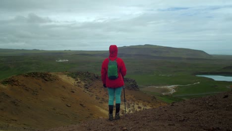 dramatic-iceland-landscape,-person-hiking-on-trail-and-enjoying-the-view,-krysuvik-seltun-area,-camera-following-movmement,-camera-tracking---dolly-in-on-a-steadicam-gimbal-stabiliser