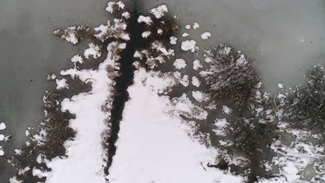 Blick-Von-Oben-Nach-Unten-Auf-Den-Zugefrorenen-See,-Der-Mit-Schnee-Bedeckt-Ist