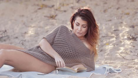 Medium-shot-of-a-beautiful-woman-reading-on-the-beach