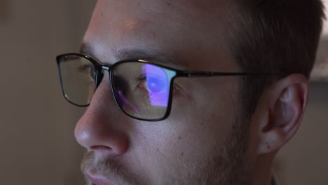Close-up-of-man-wearing-blue-light-blocking-glasses-looking-at-screen