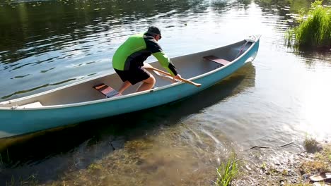 Man-getting-into-canoe-on-lake