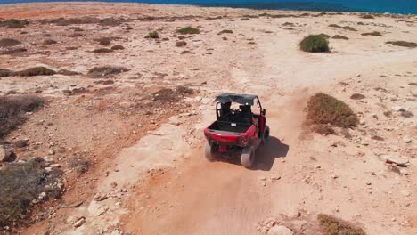 A-couple-speed-off-across-rocky-terrain-in-a-four-wheeler-while-off-road
