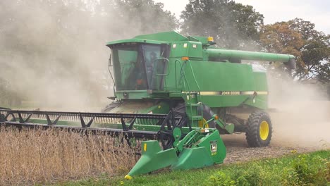 Slow-motion-panning-shot-of-a-John-Deere-9600-harvesting-soybeans-in-a-farm