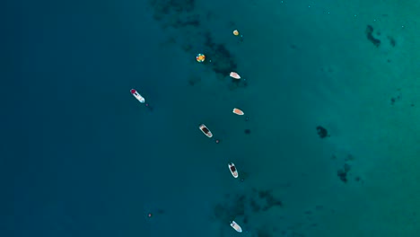 Aerial-view-looking-down-on-anchored-leisure-speed-boats-in-the-blue-sea