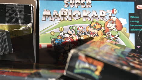 Caja-De-Kart-De-Super-Mario-Vintage-Con-Otros-Juegos-Que-Rodean-La-Diapositiva-A-La-Derecha