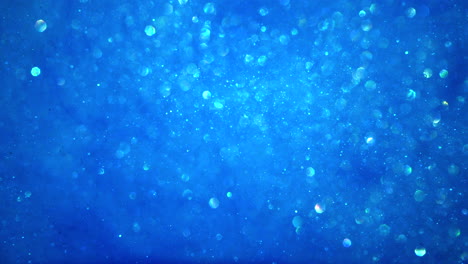Abstrakter-Hellblauer-Funkelnder-Partikelhintergrund-Mit-Bokeh-Lichtern-Und-Glänzenden-Gefrorenen-Kristallen-In-Wasserschleife