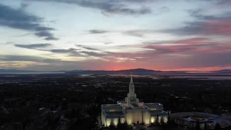 Drone-flies-backwards-away-from-LDS-temple-at-sunset