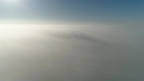Flight-over-misty-clouds-in-morning-sunlight-with-little-glory-and-city-scape-under-clouds