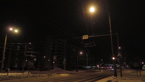 Flashing-red-lights-at-night-in-dark-street-with-snow-falling-and-orange-glowy-lights