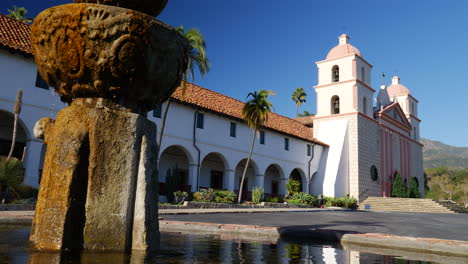 Das-Historische-Santa-Barbara-Missionsgebäude-Mit-Spanisch-katholischer-Architektur-Und-Brunnen,-Der-Eine-Wasserrutsche-Reflektiert-Und-Plätschert,-Rechts