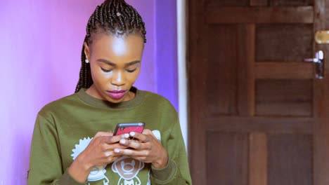 Mujer-Africana-Escribiendo-Un-Mensaje-De-Texto-Por-Teléfono-Con-Aspecto-Serio-Y-Estresado