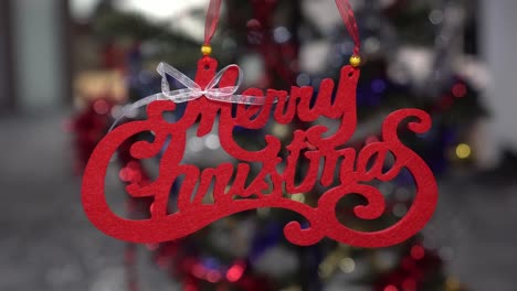 Handheld-shot-of-a-Merry-Christmas-sign,-decoration-with-blurred-background