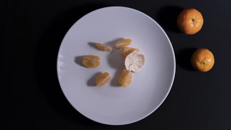 Peeling-a-tangerine-on-the-white-plate
