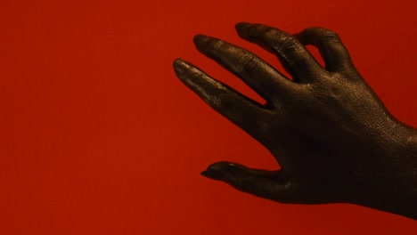 Junge-Weibliche-Handgemalt-Mit-Schwarzer-Farbe,-Die-Sich-Reibungslos-In-Einem-Roten-Hintergrund-Bewegt