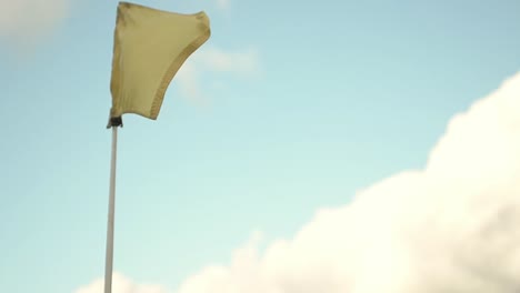Yellow-golf-flag-flying-in-wind