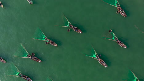 Eine-Luftaufnahme-über-Hunderte-Von-Traditionellen-Konischen-Korbbooten-Und-Trawler-fischerbooten-Im-Ozean-Vietnam-Asien