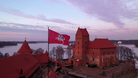 AERIAL:-Still-Shot-of-Waving-Lithuanian-Flag-with-White-Vytis-on-a-Red-Field-on-the-Top-of-Trakai-Island-Castle-Gate-Tower