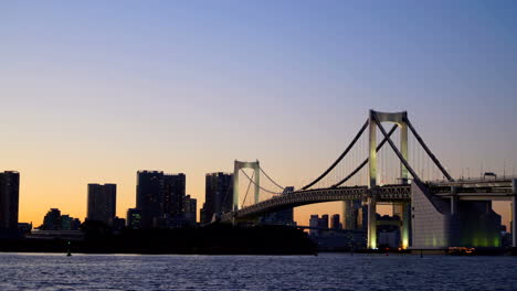Tokio-Japón---Alrededor-Del-Día-A-La-Noche-Lapso-De-Tiempo-De-Un-Puente-Con-Tráfico-Y-El-Horizonte-En-El-Fondo