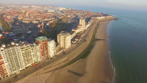 Aerial:-The-boulevard,-beach-and-city-of-Vlissingen-during-sunset