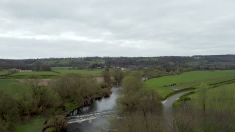 Aerial-Pedestal-Reveal-Shot-of-North-Yorkshire-Countryside-Lane,-River-and-Fields-in-Spring