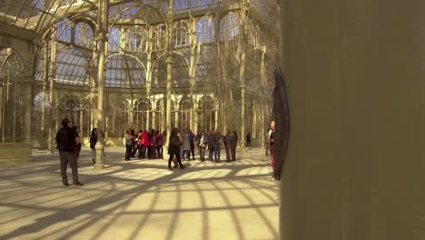 Turistas-Dentro-Del-Palacio-De-Cristal-Interior,-Parque-Del-Retiro,-Madrid,-Slow-Pan-Wide