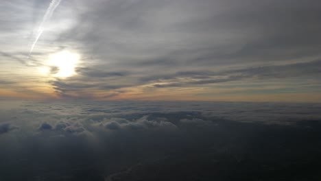 Stimmungsvoller-Und-Bewölkter-Himmel-Während-Des-Sonnenuntergangs,-Gefilmt-Aus-Dem-Flugzeugfenster