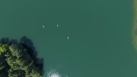Antena-De-Kayaks-Pasándose-Unos-A-Otros-En-Un-Hermoso-Lago-De-Color-Verde-Durante-Una-Calurosa-Y-Luminosa-Tarde-De-Verano-En-Wisconsin,-Ee.uu.