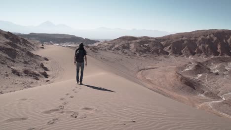 Hombre-Caminando-Sobre-Las-Dunas-De-Arena-Del-Desierto