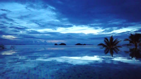 Zeitraffer-Blauer-Sonnenuntergang-Mit-Reflexionen-Am-Infinity-Pool