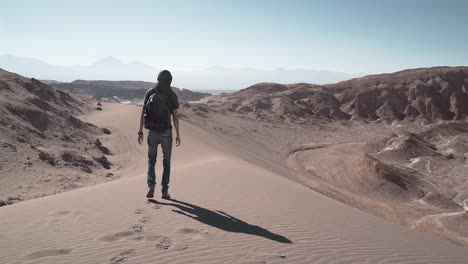 Man-slow-motion-walking-in-the-desert-sand-dunes