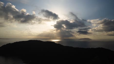 Sonnenaufgangszeitraffer-Mit-Sonnenstrahlen-Durch-Die-Wolken-Von-Der-Spitze-Eines-Berges