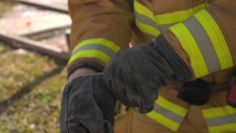 Feuerwehrmann-Zieht-Handschuhe-An,-Um-Bereit-Zu-Sein,-Ein-Feuer-Zu-Bekämpfen