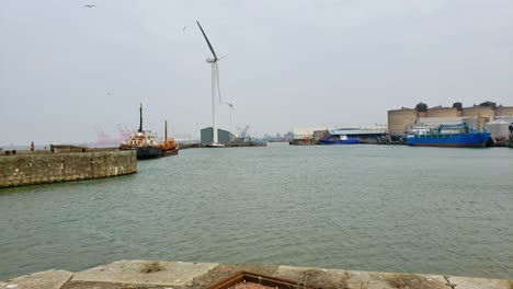 Dockland-Waterfront-Mit-Windgenerator-Und-Altem-Schiff-Im-Hafen-Angedockt
